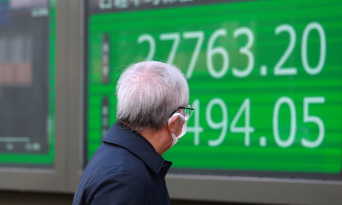 A man looks at an electronic stock board of a securities firm in Tokyo, Japan, on Jan. 19, 2022. (Koji Sasahara/AP Photo)