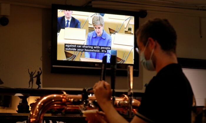 Undated photo showing a Bartender at work while a TV screen were showing Scotland's First Minister Nicola Sturgeon. (Andrew Milligan/PA)