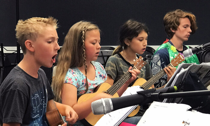 Intermediate students play at the Parents Progress Recital at Musical Mentors in San Clemente, Calif., in 2019. Maki (R) is the volunteer mentor for this group, having gone through the entire program himself. (Courtesy of Duff Rowden)