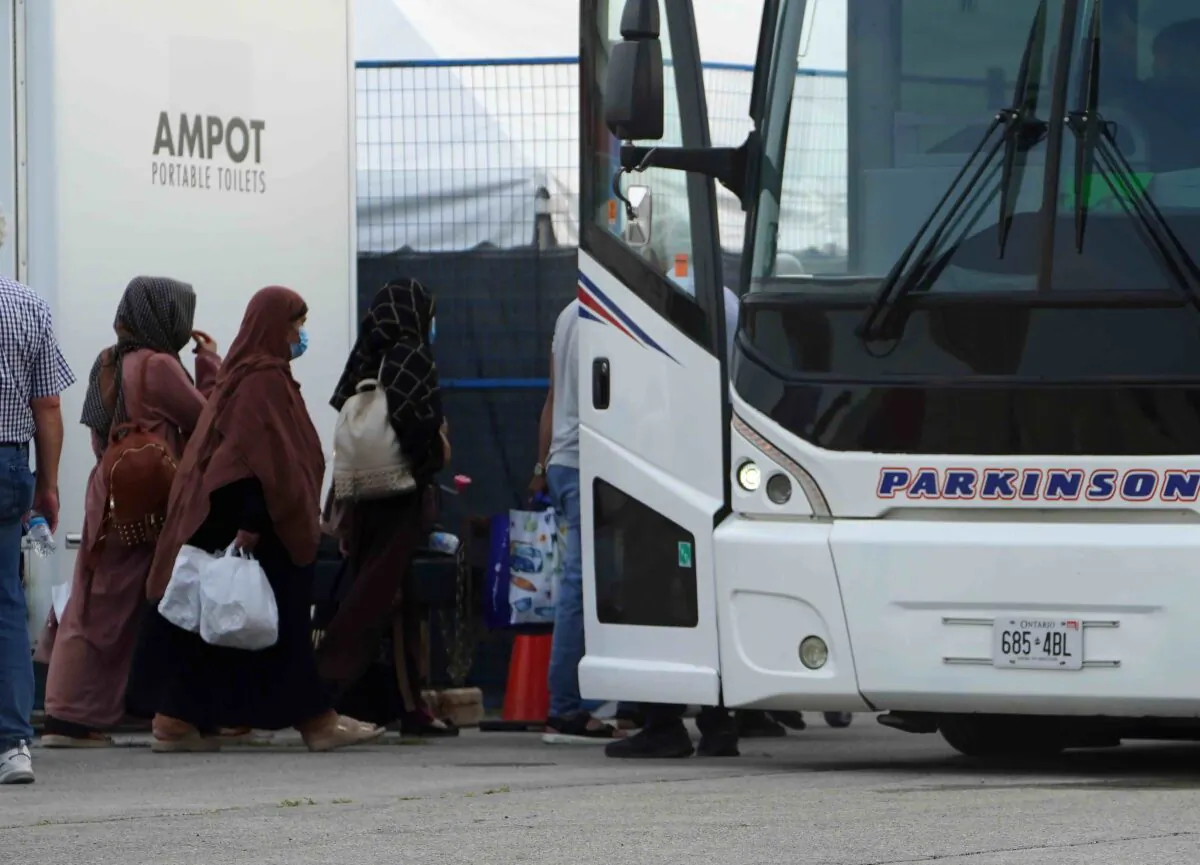 Refugees from Afghanistan board a bus after being processed at Pearson Airport in Toronto, Aug 17, 2021. (The Canadian Press/Sean Kilpatrick)
