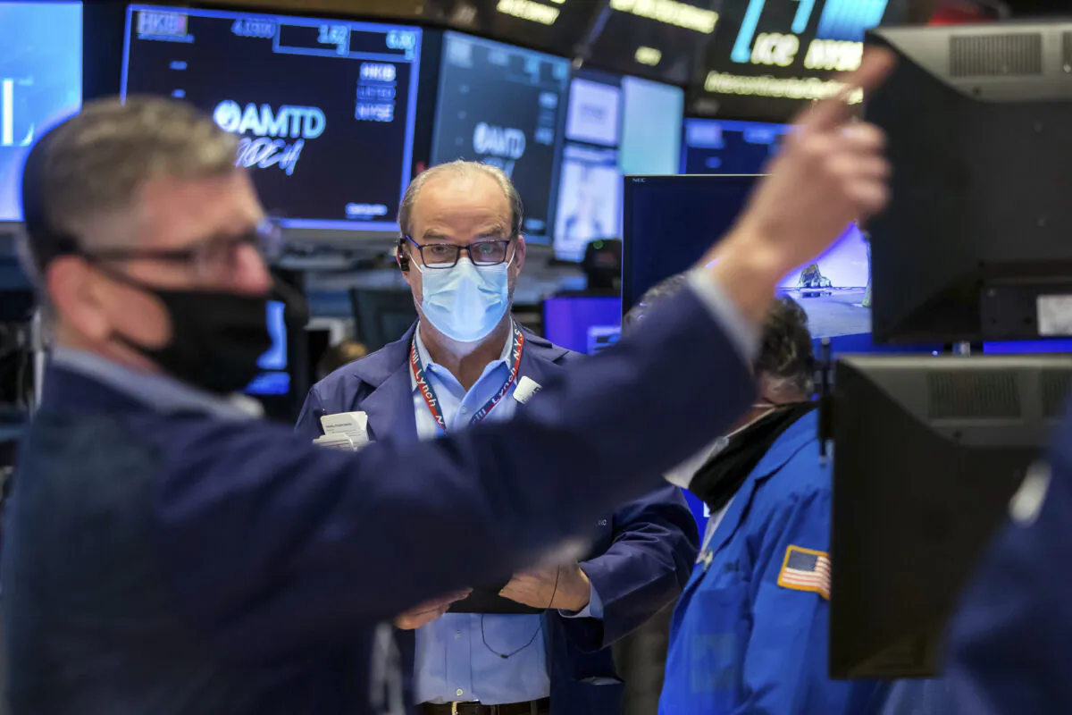 Trader David O'Day, center, works on the New York Stock Exchange trading floor on Jan. 20, 2022. (Courtney Crow/New York Stock Exchange via AP)