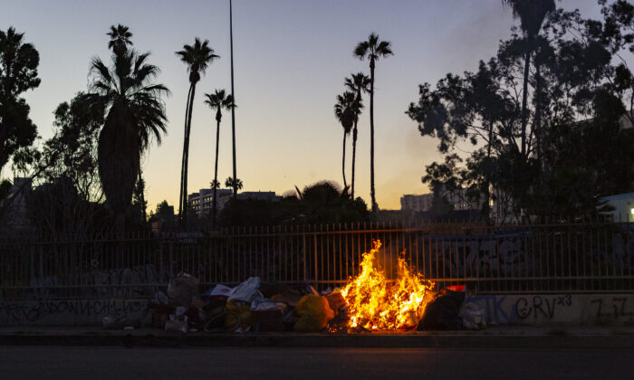 A fire burns in a homeless encampment in Los Angeles on Jan. 20, 2022. (John Fredricks/The Epoch Times)