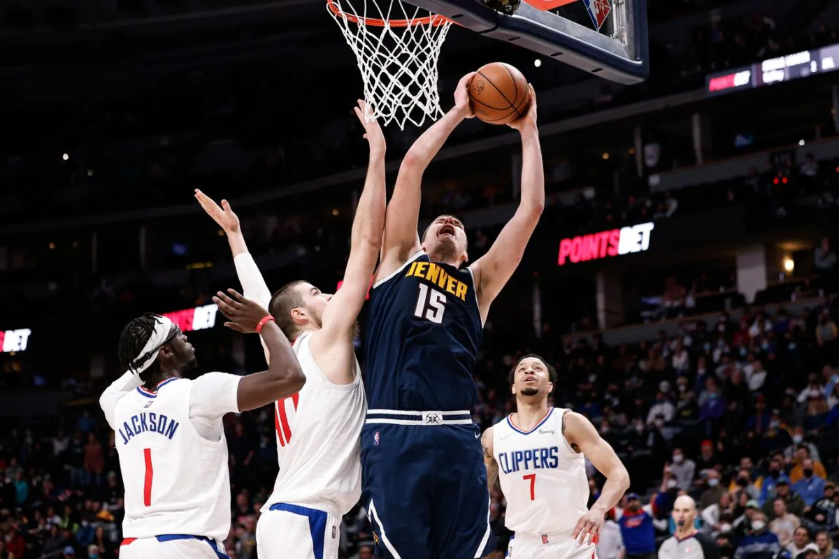 Denver Nuggets center Nikola Jokic (15) drives to the net against Los Angeles Clippers center Ivica Zubac (40) and guard Reggie Jackson (1) as guard Amir Coffey (7) defends in overtime at Ball Arena, in Denver, on Jan. 19, 2022. (Isaiah J. Downing/USA TODAY Sports via Field Level Media)