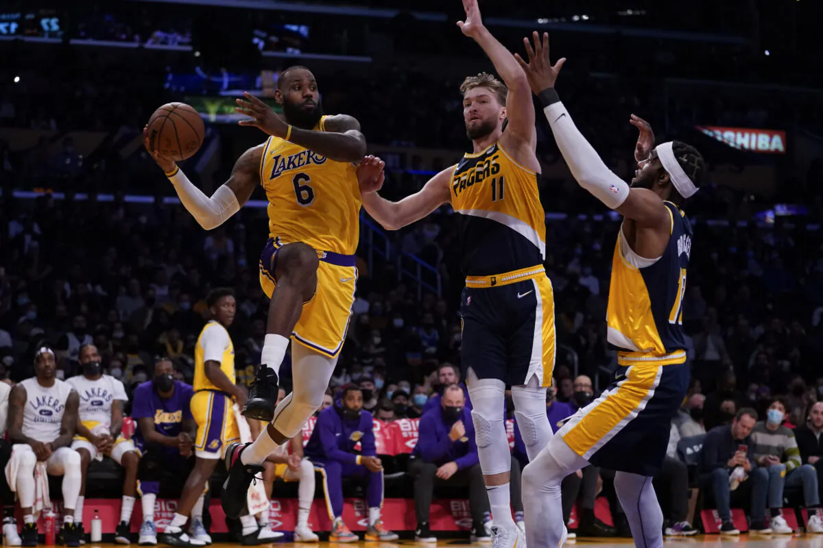 Los Angeles Lakers forward LeBron James (6) passes against Indiana Pacers forward Domantas Sabonis (11) and forward Oshae Brissett (12) during the first half of an NBA basketball game in Los Angeles on Jan. 19, 2022. (Ashley Landis/AP Photo)