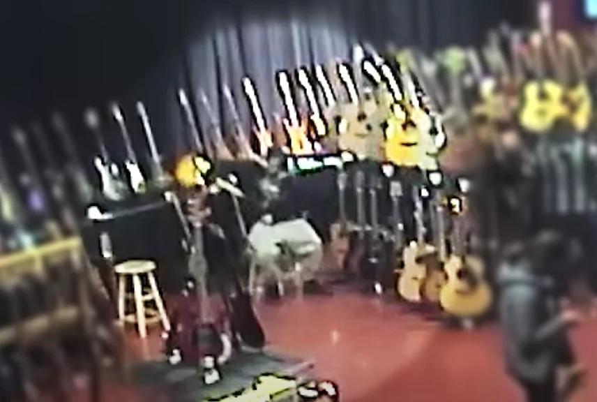 In this surveillance image, a suspect described as a man in his 20s appears to stuff a Les Paul guitar down his pants.(Youtube/York Regional Police)