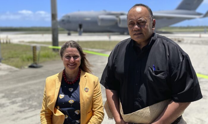 The Prime Minister of Tonga, Siaosi Sovaleni, (R), joins the Australian High Commissioner to Tonga, Rachael Moore, to watch the arrival of the first Royal Australian Air Force C-17A Globemaster III aircraft at Fua'amotu International Airport near Nukuʻalofa, Tonga, on Jan. 20, 2022. (Australian Defence Force via AP)