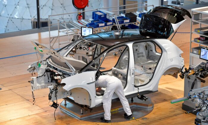 A technician works in the assembly line of German carmaker Volkswagen's electric ID. 3 car in Dresden, Germany, on June 8, 2021. (Matthias Rietschel/Reuters)