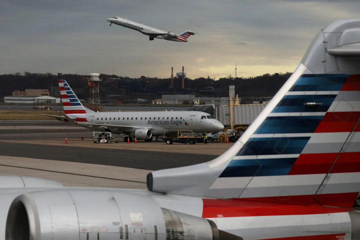 A jet from American Eagle, a regional branch of American Airlines (AA), takes off past other AA aircraft at Ronald Reagan Washington National Airport in Arlington, Va., on Dec. 3, 2021. (Chris Helgren/Reuters)
