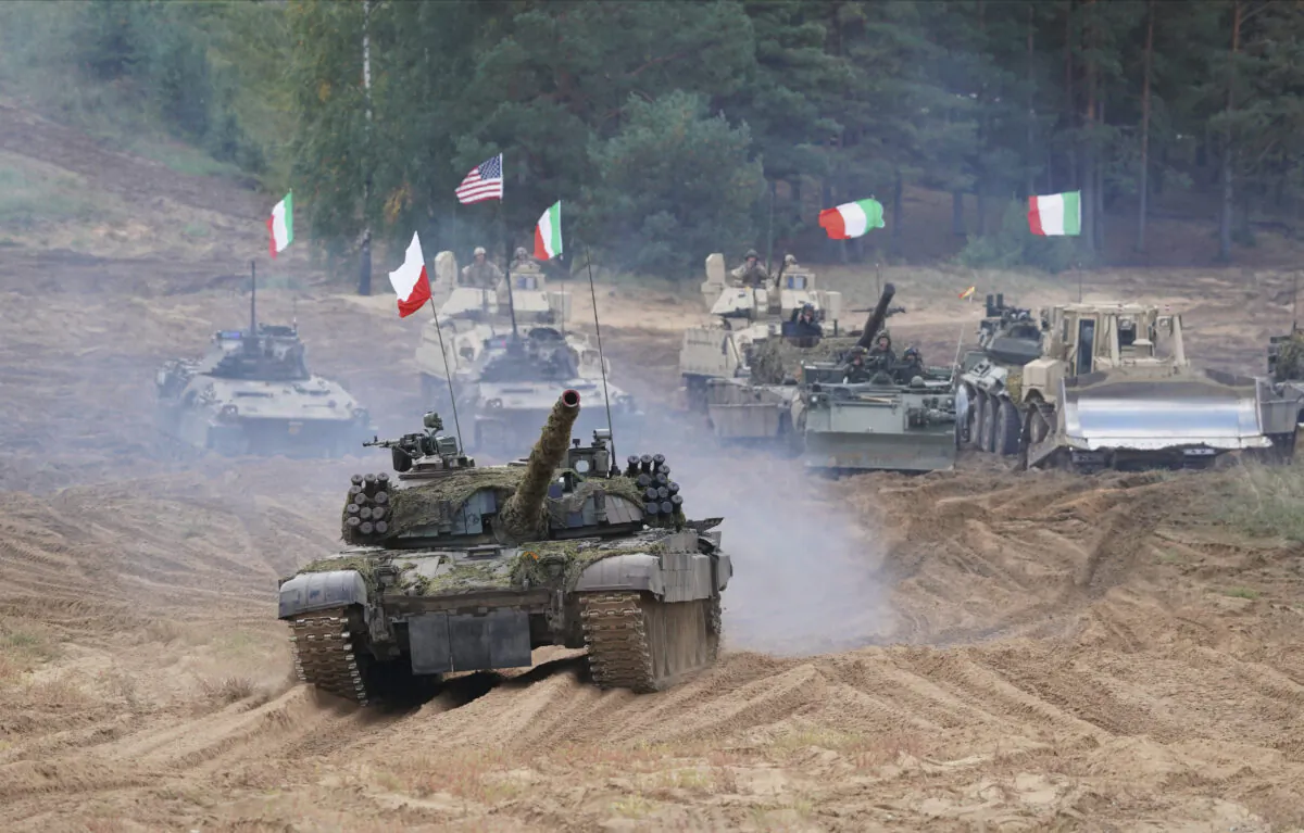 Military vehicles and tanks of Poland, Italy, Canada, and the United States roll during the NATO military exercises “Namejs 2021” at a training ground in Kadaga, Latvia, on Sept. 13, 2021. (AP/Roman Koksarov)