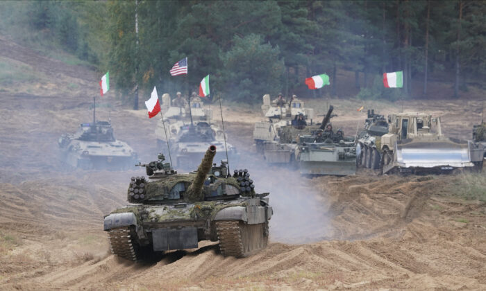 Military vehicles and tanks of Poland, Italy, Canada and United States roll during the NATO military exercises ''Namejs 2021'' at a training ground in Kadaga, Latvia, on Sept. 13, 2021. (AP/Roman Koksarov)