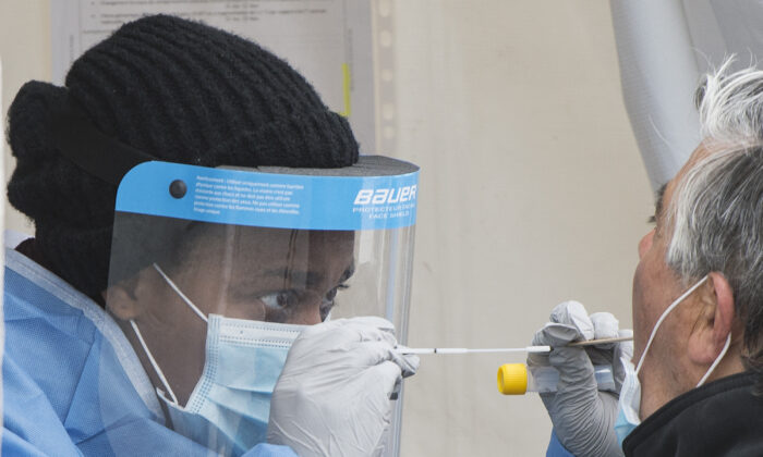 A health-care worker prepares to swab a man at a walk-in COVID-19 test clinic in Montreal North on May 10, 2020. (The Canadian Press/Graham Hughes)