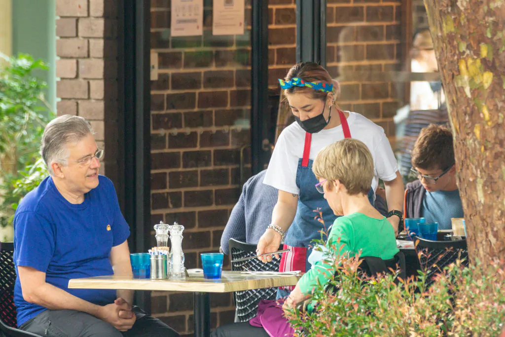 A waitress is seen delivering cutlery at a cafe in Mosman, Sydney, Australia, on Jan. 3, 2021. (Jenny Evans/Getty Images)