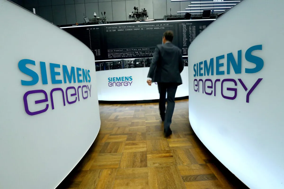 A trader walks next to Siemens Energy AG logos during Siemens Energy's initial public offering (IPO) at the Frankfurt Stock Exchange in Frankfurt, Germany, on Sept. 28, 2020. (Ralph Orlowski/Reuters)