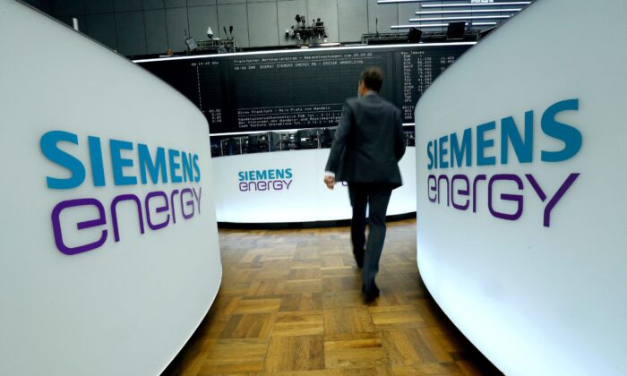 A trader walks next to Siemens Energy AG logos during Siemens Energy's initial public offering (IPO) at the Frankfurt Stock Exchange in Frankfurt, Germany, on Sept. 28, 2020. (Ralph Orlowski/Reuters)