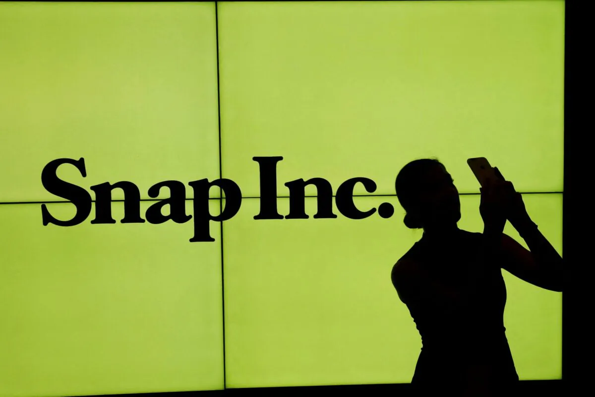 A woman stands in front of the logo of Snap Inc., on the floor of the New York Stock Exchange (NYSE) in New York City, on March 2, 2017. (Lucas Jackson/Reuters)