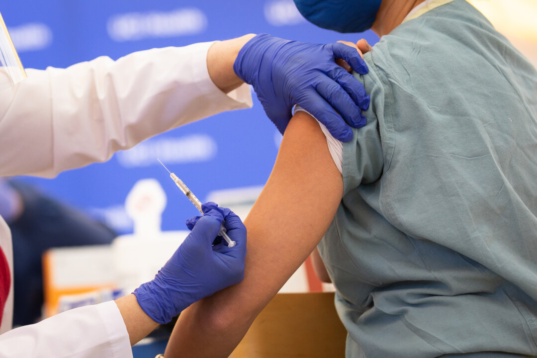 A medical staff receives a COVID-19 vaccination in Orange, Calif., on Dec. 16, 2020. (John Fredricks/The Epoch Times)