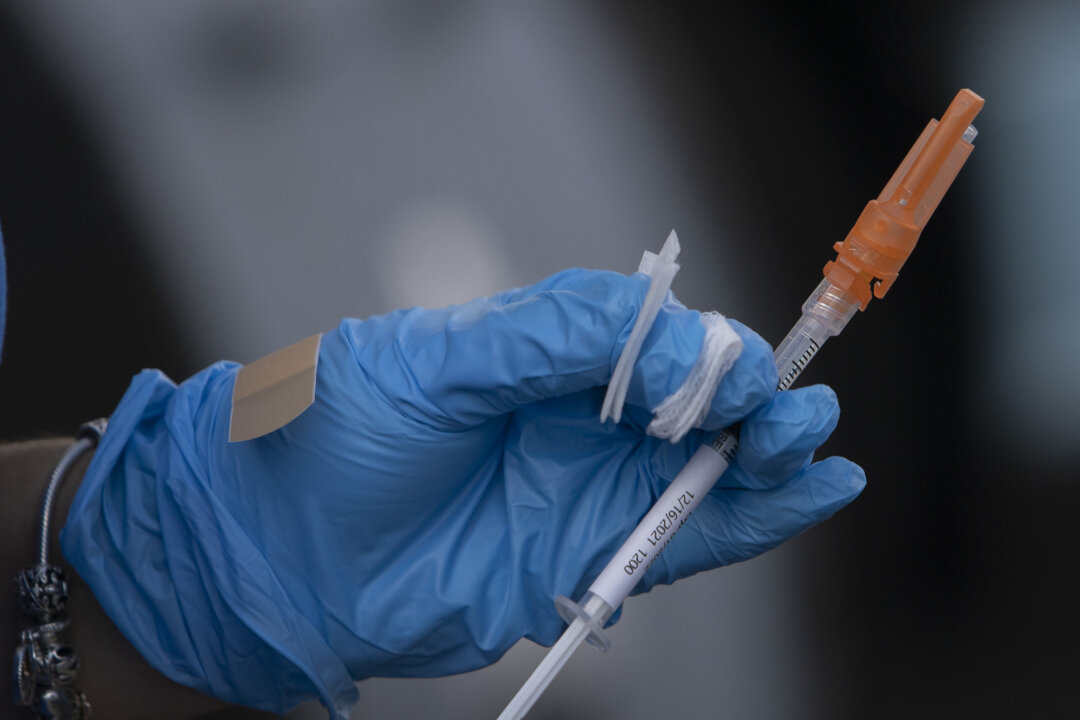 A healthcare worker holds a Pfizer-BioNTech COVID-19 vaccine in Miami, Fla., on Dec. 16, 2021. (Joe Raedle/Getty Images)