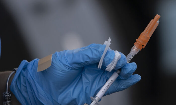 A healthcare worker holds a Pfizer-BioNTech COVID-19 vaccine in Miami, Fla., on Dec. 16, 2021. (Joe Raedle/Getty Images)