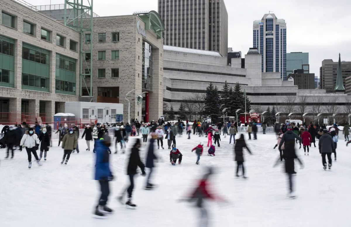 People ice skate on the Rink of Dreams at City Hall in Ottawa on Dec. 28, 2021. (The Canadian Press/Justin Tang)