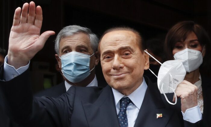 Former Italian Premier Silvio Berlusconi waves to reporters as he arrives at the Chamber of Deputies to meet Mario Draghi, in Rome, on Feb. 9, 2021. Alessandra Tarantino/AP Photo)