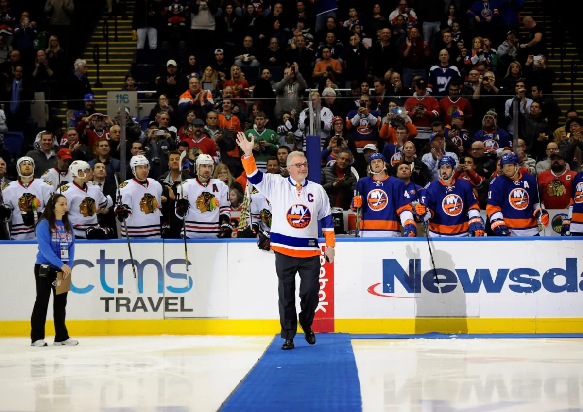 Former New York Islander Clark Gillies waves to fans before he dropped a ceremonial puck before the Islanders' NHL hockey game against the Chicago Blackhawks at Nassau Coliseum in Uniondale, New York, on Dec. 13, 2014. (Kathy Kmonicek/AP Photo)