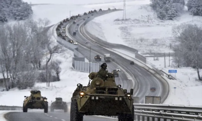 A convoy of Russian armored vehicles moves along a highway in Crimea on Jan. 18, 2022. (AP Photo)