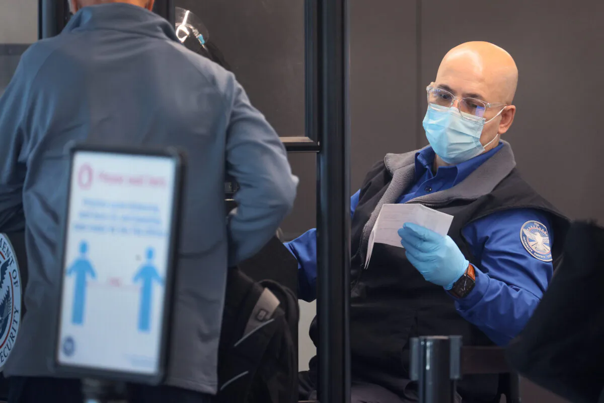A Transportation Security Administration worker screens a passenger at O'Hare International Airport in Chicago, Ill., in a file image. (Scott Olson/Getty Images)