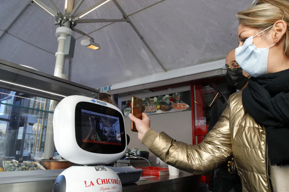 A machine checks a woman's vaccine pass, at a restaurant in Lille northern France, on Jan. 24, 2022. (Michel Spingler/AP Photo)