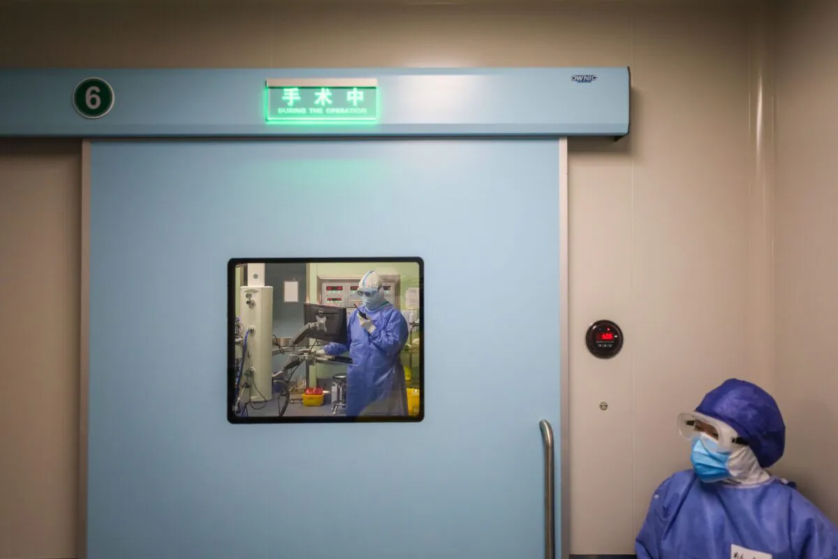 A medical staff member waits outside the operating room as doctors perform a caesarean section at a gynaecology and obstetrics isolation ward in Xiehe hospital in Wuhan, Hubei Province on March 7, 2020. (STR/AFP via Getty Images)