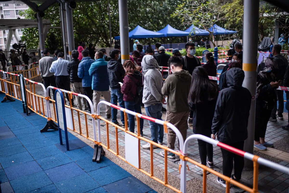 Residents wait in line to test for the COVID-19 outside a building placed under lockdown at the Kwai Chung Estate public housing complex in Hong Kong on Jan. 22, 2022. (Louise Delmotte/AFP via Getty Images)
