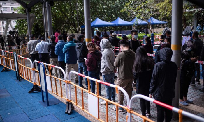 Residents wait in line to test for the COVID-19 outside a building placed under lockdown at the Kwai Chung Estate public housing complex in Hong Kong on Jan. 22, 2022. (Louise Delmotte/AFP via Getty Images)