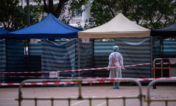 A health worker waits for residents to be screened for COVID-19 at a makeshift testing station outside a building placed under lockdown at the Kwai Chung Estate public housing complex in Hong Kong on Jan. 22, 2022. (Louise Delmotte/AFP via Getty Images)