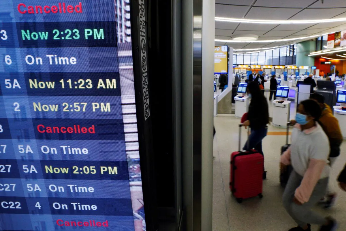 A board displays the status of flights to and from Logan International Airport, amid cancellations and disruptions due to adverse weather and the surge in coronavirus cases caused by the Omicron variant, in Boston, on Jan. 3, 2022. (Brian Snyder/Reuters)