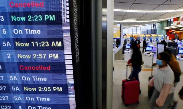 The board will show the status of flights to and from Logan International Airport in Boston on January 3, 2022, amid cancellations and confusion due to bad weather, and a surge in coronavirus cases caused by Omicron variants. ..  (Brian Snyder / Reuters)