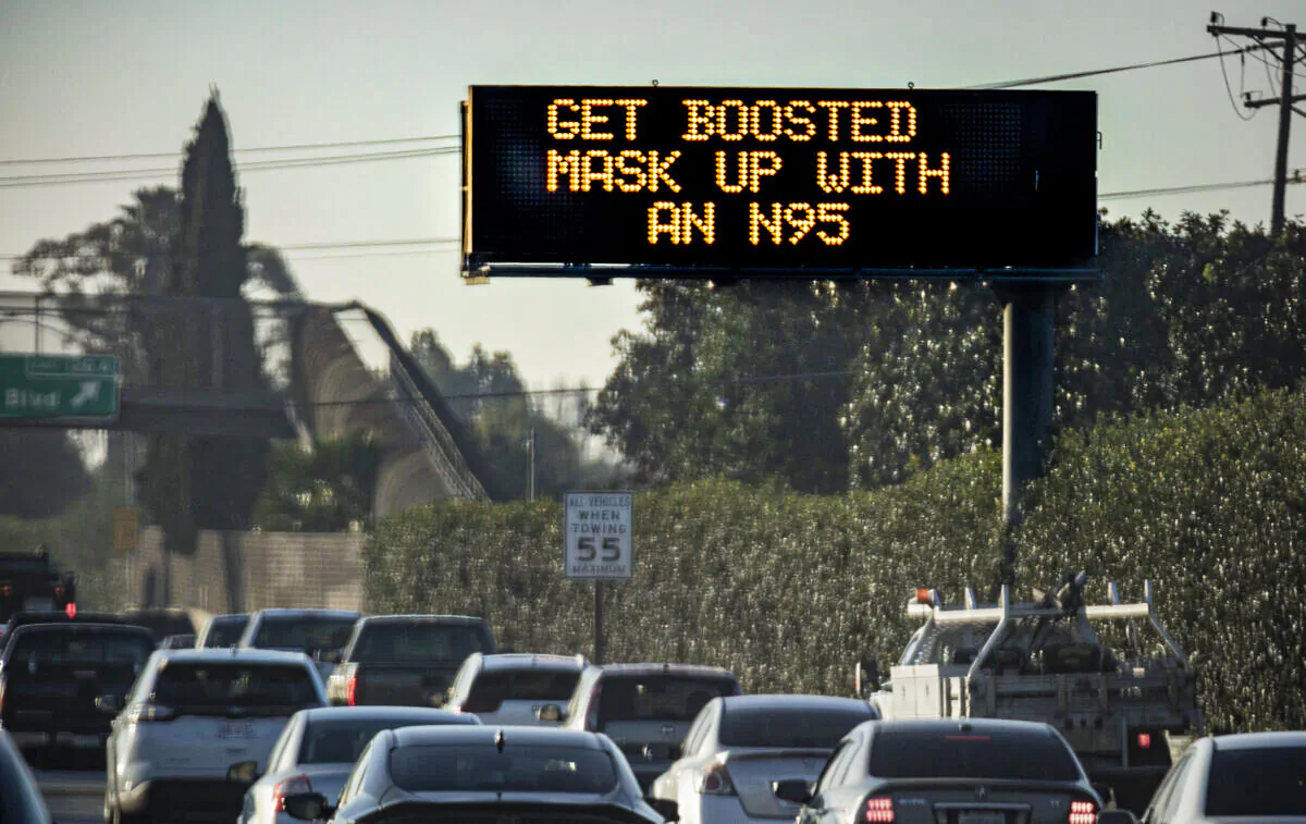 A freeway sign displaying a COVID-19 message shines above the 5 Freeway in Los Angeles, Calif., on Jan. 20, 2022. (John Fredricks/The Epoch Times)