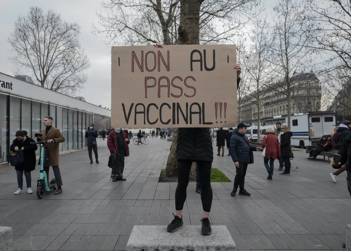 Demonstrator holds a placard that reads 'No to vaccine pass' during a rally in Paris, on Jan. 22, 2022. (Rafael Yaghobzadeh/AP Photo)
