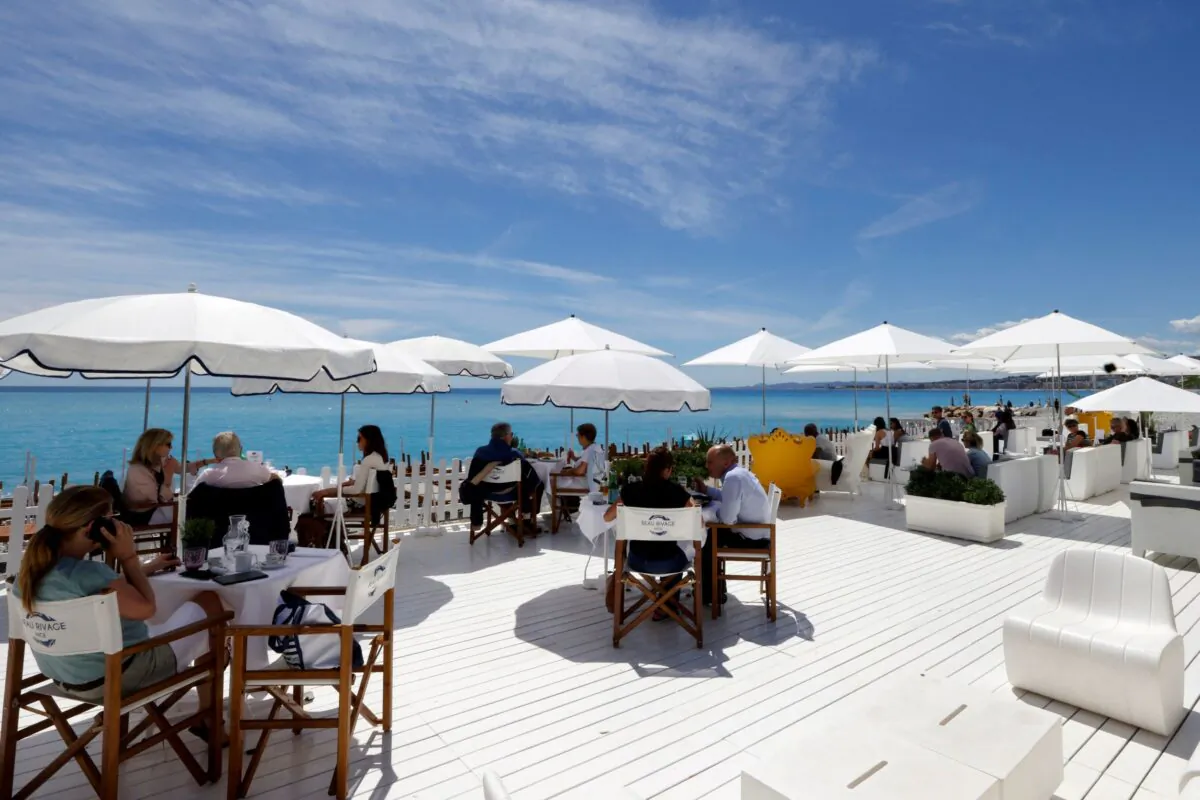Customers enjoy a lunch on the terrace of a beach restaurant in Nice as cafes, bars and restaurants reopen after closing down for months amid the coronavirus disease (COVID-19) outbreak in France, on May 19, 2021. (Eric Gaillard/Reuters)
