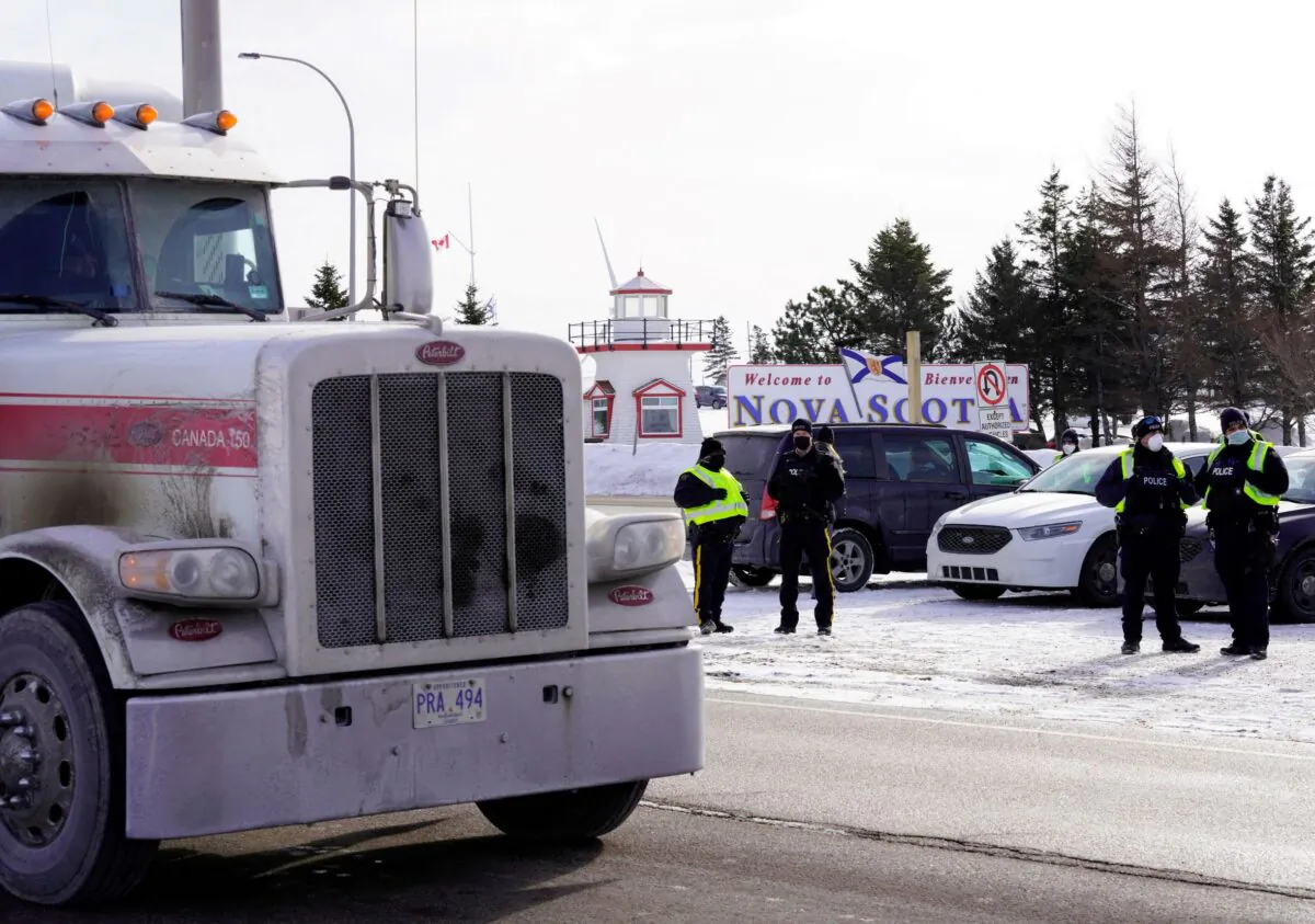 A truck passes by the Canadian truck convoy/protest along the New Brunswick/Nova Scotia border in Fort Lawrence, Nova Scotia, Canada, on Jan. 23, 2022. (John Morris/Reuters)