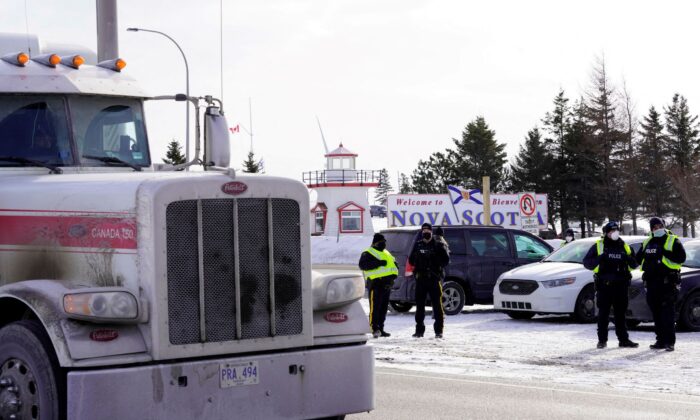 A truck passes by the Canadian truck convoy/protest along the New Brunswick/Nova Scotia border in Fort Lawrence, Nova Scotia, Canada, on Jan. 23, 2022. (John Morris/Reuters)