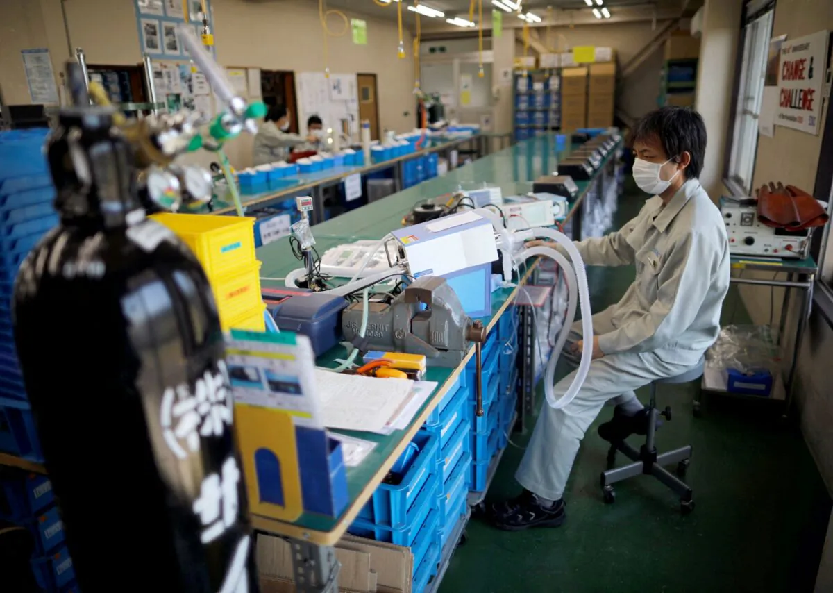 Employees of Sanko Manufacturing Co. are seen at the assembly line of the company's ventilators at a factory in Saitama, north of Tokyo, Japan, on May 8, 2020. (Issei Kato/Reuters)