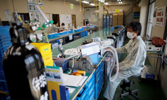 Employees of Sanko Manufacturing Co. are seen at the assembly line of the company's ventilators at a factory in Saitama, north of Tokyo, Japan, on May 8, 2020. (Issei Kato/Reuters)