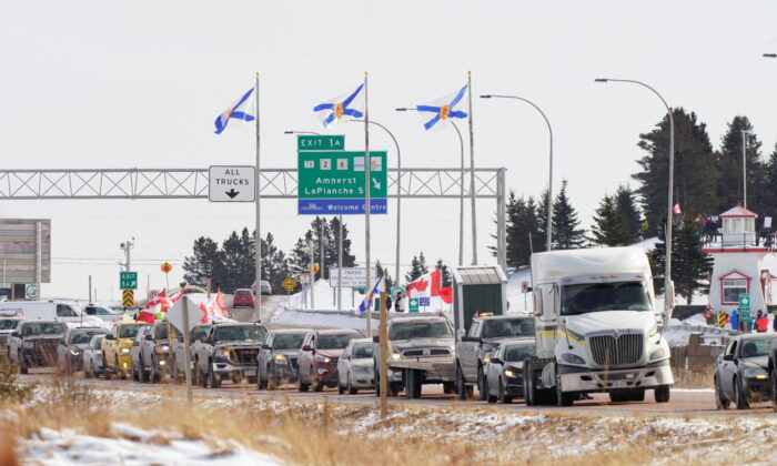 Truck drivers and supporters heading to Ottawa to demonstrate against vaccine mandates travel on the Nova Scotia-New Brunswick provincial boundary in Fort Lawrence, Nova Scotia, on Jan. 23, 2022. (REUTERS/John Morris)