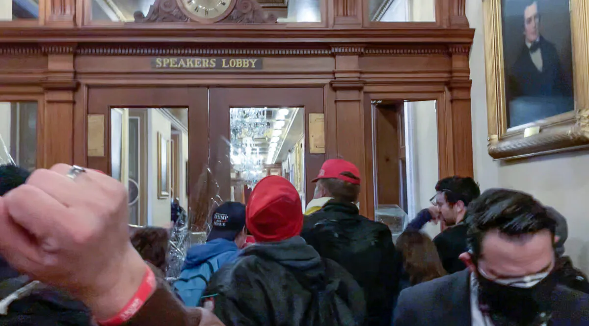 Ashli Babbitt punches rioter Zachary Alam in the face just before she climbed in a broken window leading to the Speaker's Lobby at the U.S. Capitol on Jan. 6, 2021. (Video Still / Sam Montoya for The Epoch Times)