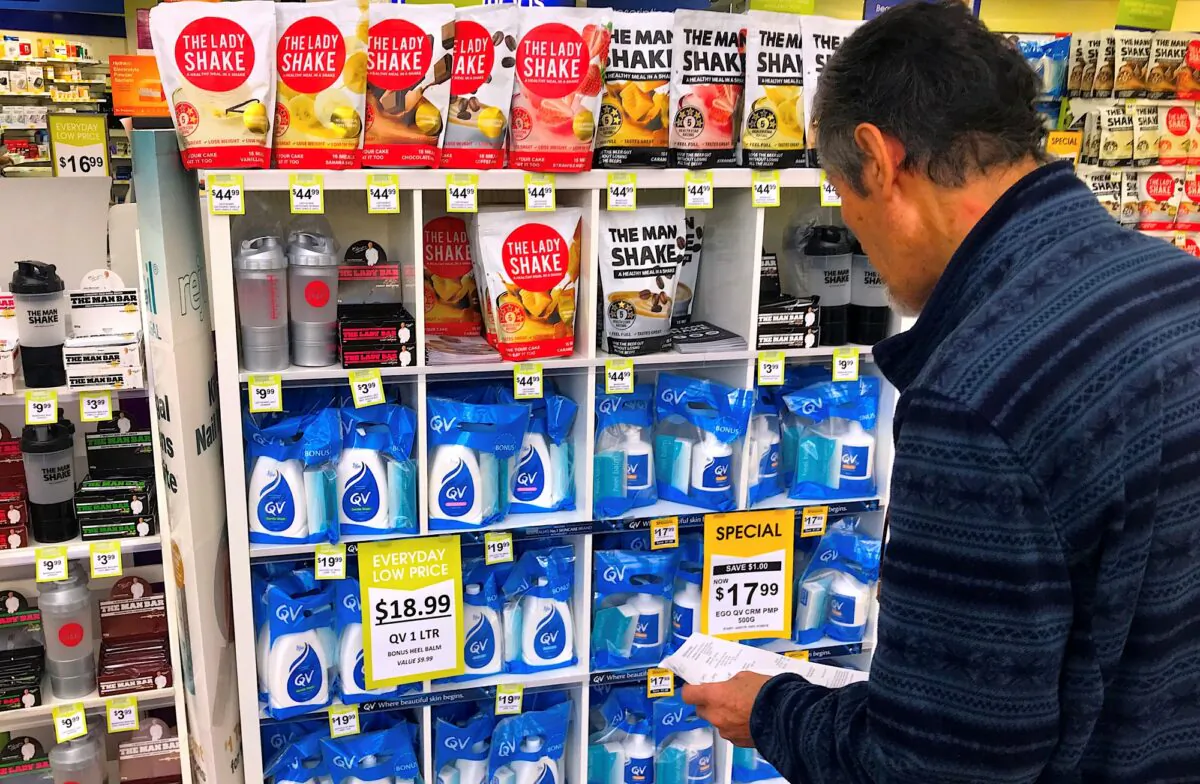 A customer looks at products marked with discounted prices on display at a chemist in a shopping mall in central Sydney, on July 25, 2018. (David Gray/Reuters)