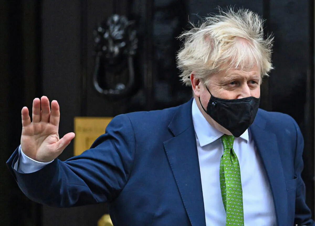 Britain's Prime Minister Boris Johnson waves as he leaves from 10 Downing Street to take part in the weekly session of Prime Minister's Questions at the House of Commons in central London on Jan. 19, 2022. (Justin Tallis/AFP via Getty Images)