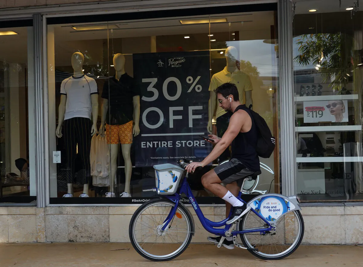 A person passes a 30 percent off sign on display in a store at the Lincoln Road mall in Miami Beach, Fla., on Dec. 14, 2021. (Joe Raedle/Getty Images)