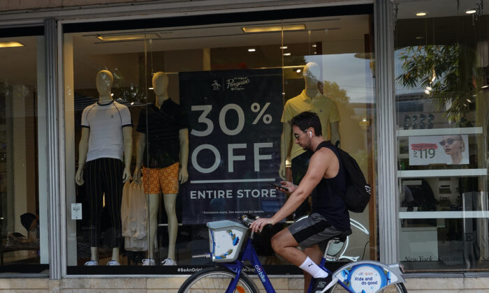 A person passes a 30 percent off sign on display in a store at the Lincoln Road mall in Miami Beach, Florida, on Dec. 14, 2021. (Joe Raedle/Getty Images)