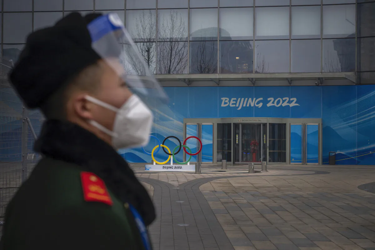 A security guard stands behind a barricade in an area not accessible to the general public, which will host the 2022 Winter Olympics at Olympic Park in Beijing on Jan. 23, 2022. (Andrea Verdelli/Getty Images)