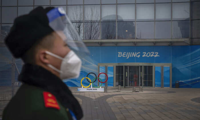 A security guard stands behind a barricade in an area not accessible to the general public, which will host the 2022 Winter Olympics at Olympic Park in Beijing on Jan. 23, 2022. (Andrea Verdelli/Getty Images)