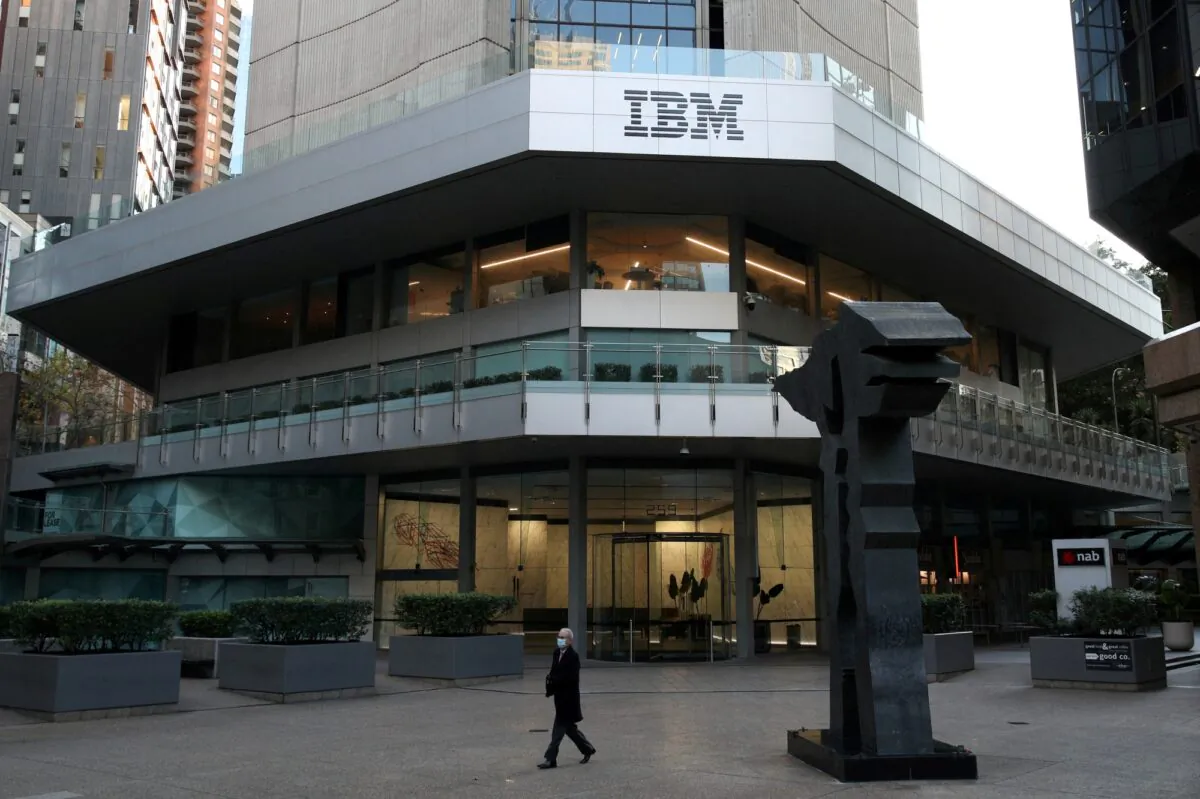 A man wearing a protective mask walks past an office building with IBM logo in the Central Business District of Sydney, on June 3, 2020. (Loren Elliott/Reuters)